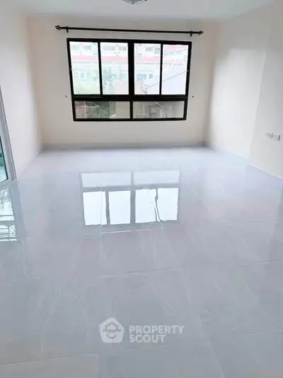 Spacious empty room with large windows and glossy tiled floor, perfect for customization.