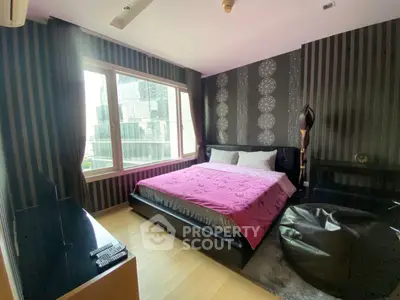 Luxurious bedroom with modern decor and large window offering city views