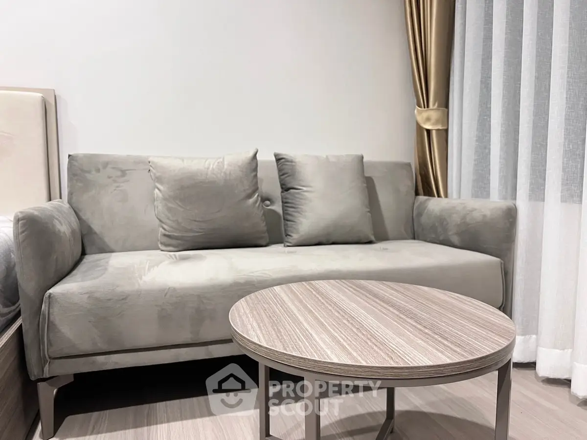 Modern living room with stylish gray sofa and elegant round coffee table