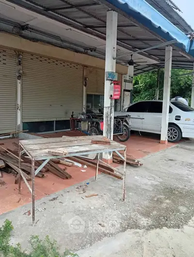 Commercial property with parking space and metal awning, ideal for small business setup.