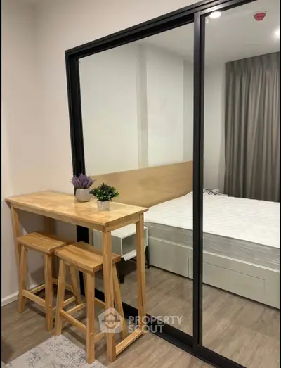 Modern bedroom with glass partition and wooden furniture, creating a cozy and stylish living space.
