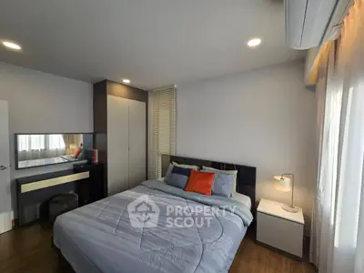 Modern bedroom with stylish decor and ample natural light, featuring a cozy bed and sleek furniture.