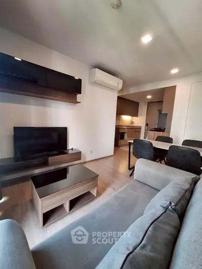Modern living room with sleek furniture and open kitchen layout in a stylish apartment.
