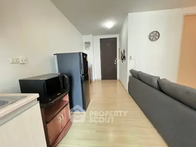 Modern apartment interior with sleek kitchen appliances and cozy living area.