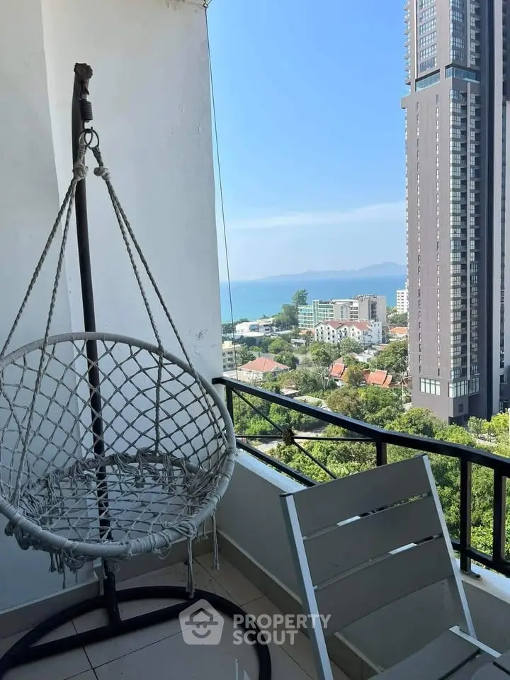 Stunning balcony view with modern high-rise and ocean backdrop