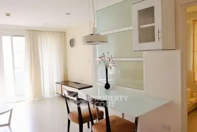 Bright modern living room with glass dining table and elegant chairs