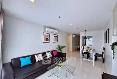 Modern living room with sleek furniture and vibrant decor in a spacious apartment.