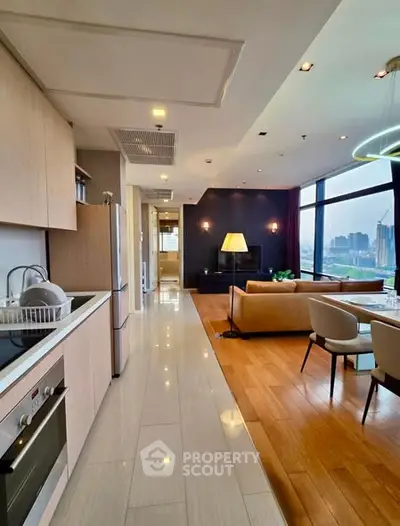 Luxurious open-plan kitchen and living room with stunning city view, modern furnishings, and elegant lighting.