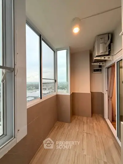 Spacious balcony with large windows offering panoramic city views, perfect for relaxation and enjoying the skyline.