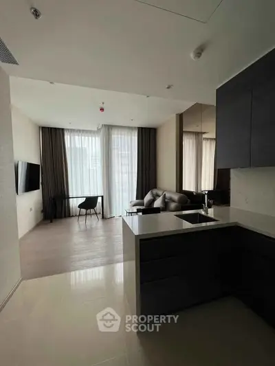 Modern open-plan living room with sleek kitchen and large windows