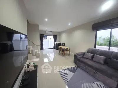 Spacious modern living room with sleek furniture and large windows offering natural light.