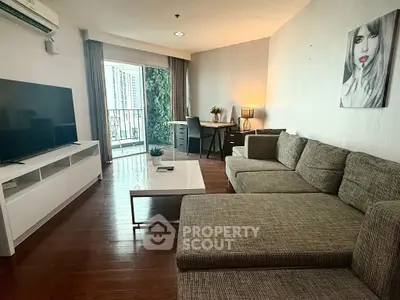 Modern living room with large TV and stylish decor, featuring a cozy sectional sofa and work desk.