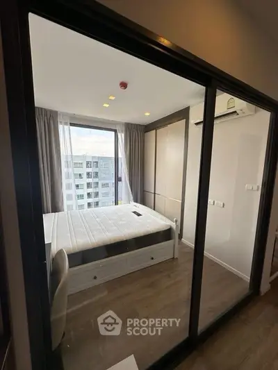 Modern bedroom with large window and sleek design in urban apartment