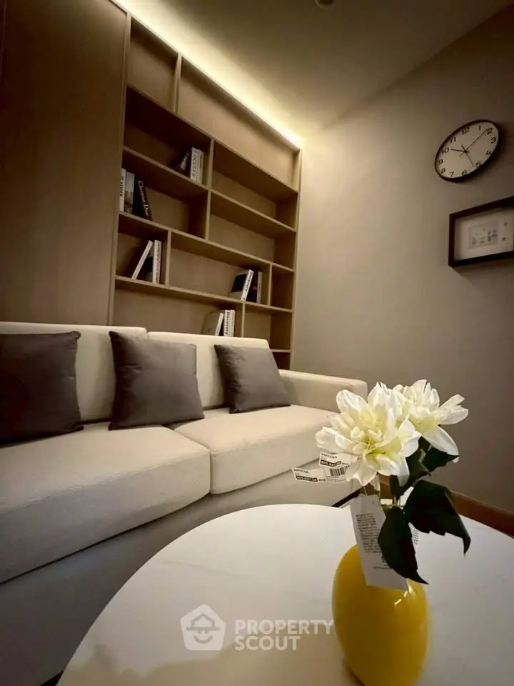 Modern living room with stylish sofa, built-in shelves, and elegant decor in a cozy setting.