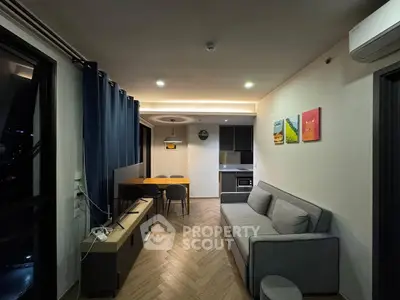 Modern living room with stylish decor and open kitchen layout, featuring a cozy sofa and dining area.
