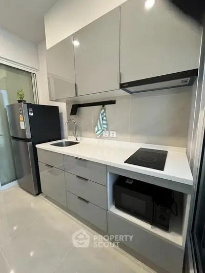 Modern kitchen with sleek cabinets and appliances in a compact layout