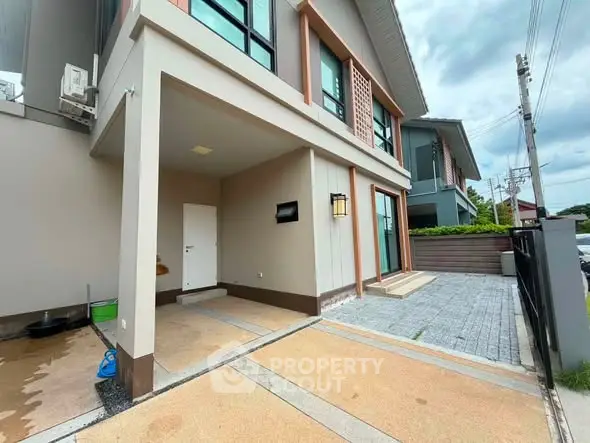 Modern townhouse exterior with driveway and contemporary design elements.