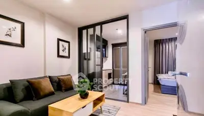 Modern apartment interior with cozy living room and view into bedroom and kitchen.