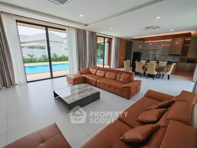 Luxurious living room with pool view, modern furniture, and elegant dining area in a spacious open layout.