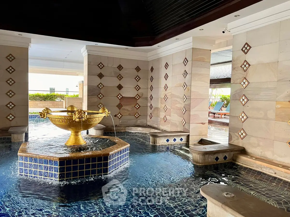 Luxurious indoor pool with elegant fountain and stylish tile design in upscale property.