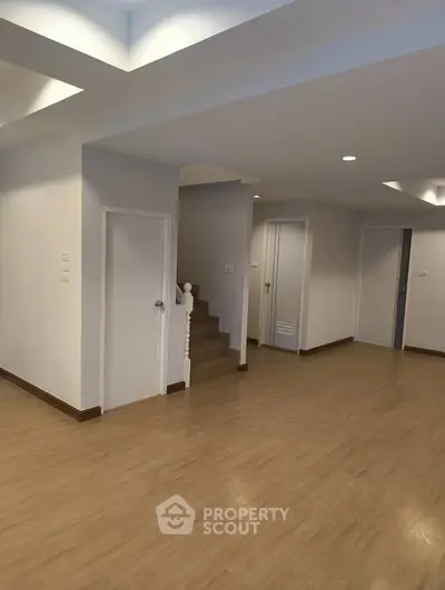 Spacious modern interior with wooden flooring and recessed lighting, ideal for versatile living arrangements.