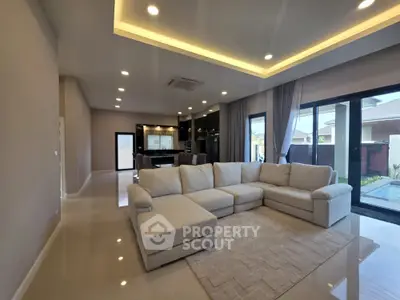 Spacious modern living room with elegant lighting and large sectional sofa, perfect for family gatherings.
