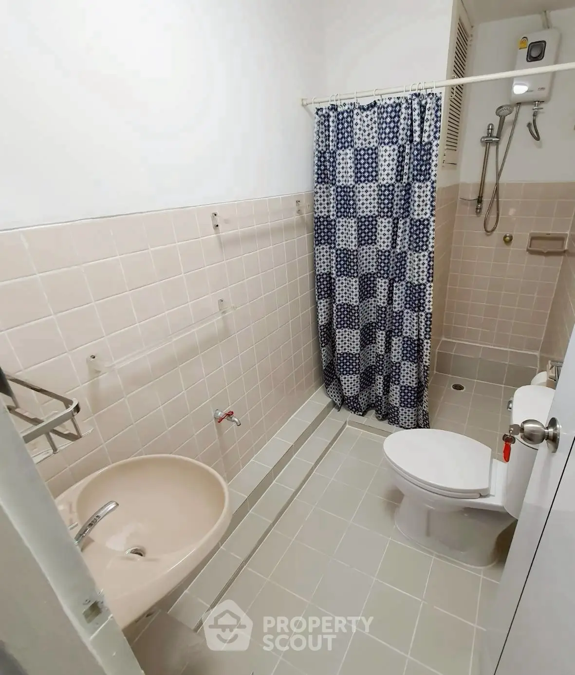 Compact bathroom with shower and checkered curtain in modern apartment.
