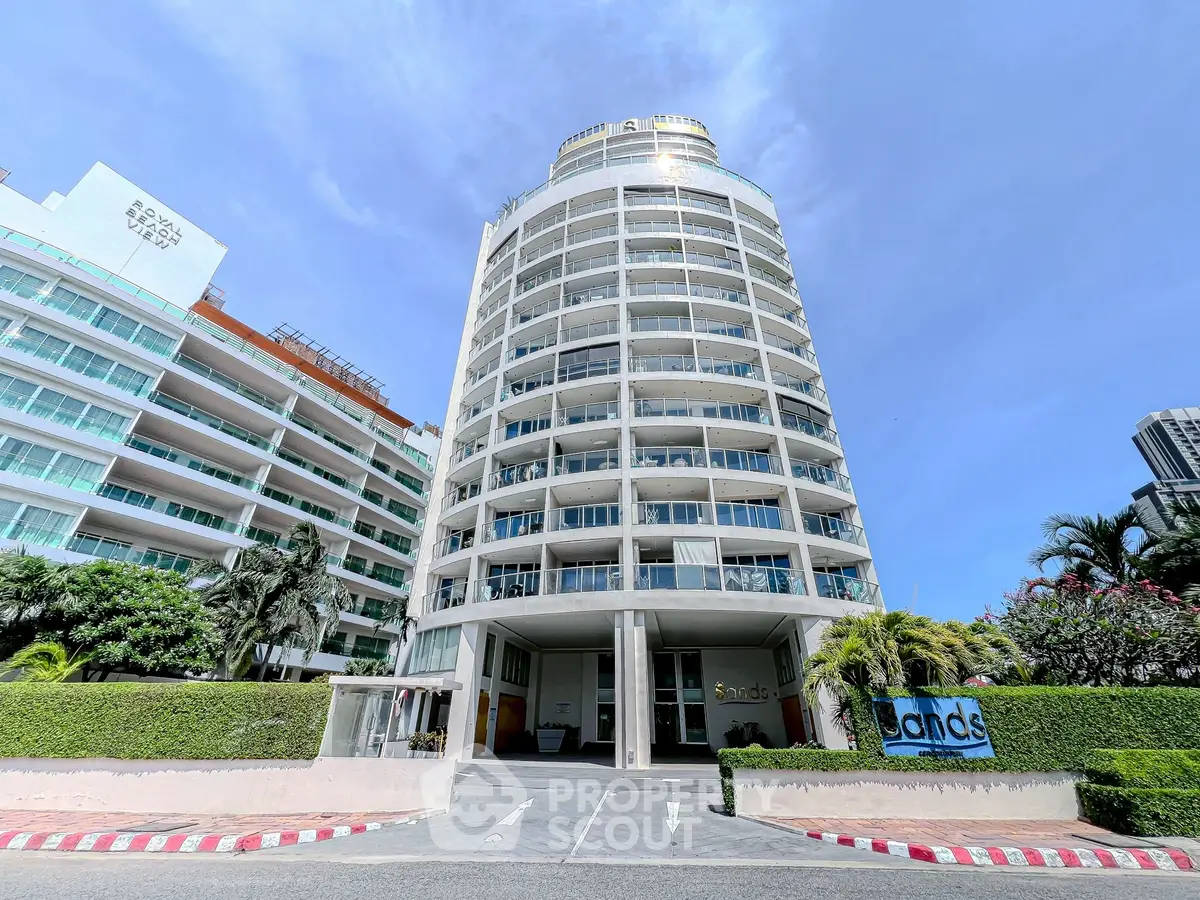 Stunning modern high-rise building with lush landscaping and clear blue skies.