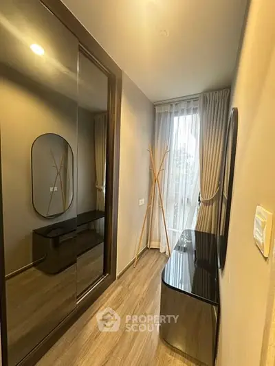 Stylish hallway with modern decor and floor-to-ceiling mirror in a contemporary apartment.