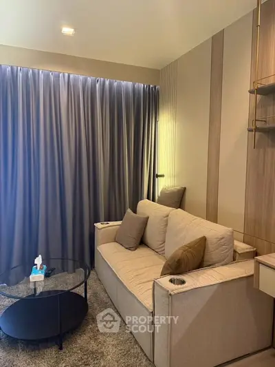 Cozy living room with modern beige sofa and elegant curtains, perfect for relaxation.