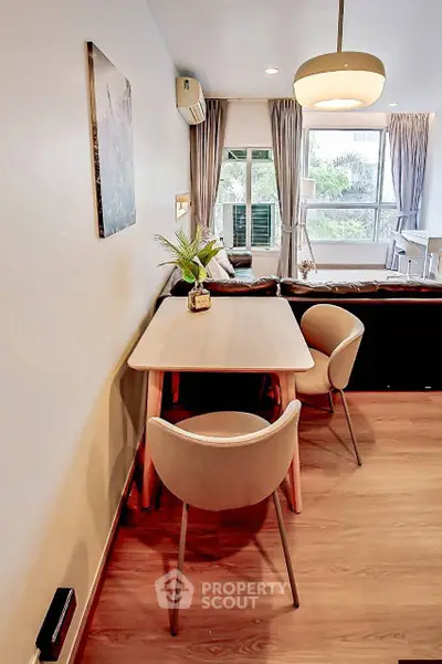 Modern living room with stylish dining area and large windows offering natural light.