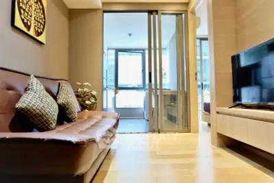 Modern living room with sleek design and sliding glass doors leading to a bright balcony.