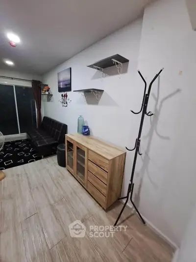 Modern living room with sleek furniture and wall shelves in a cozy apartment.