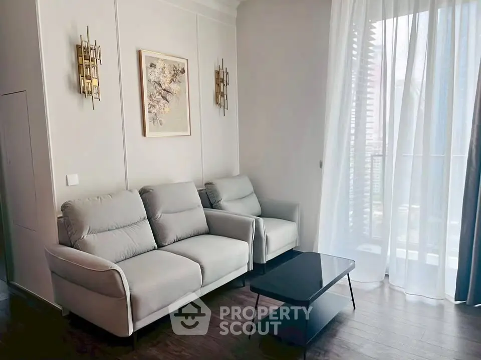 Stylish living room with modern sofa and elegant decor, featuring large window for natural light.