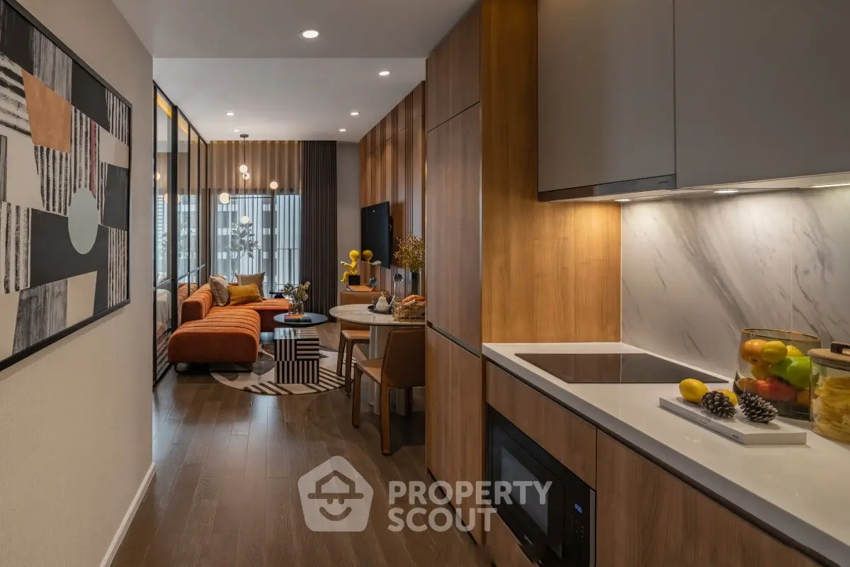 Modern open-plan kitchen and living room with stylish decor and warm lighting.