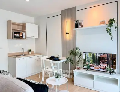 Modern living room with stylish decor, open kitchen, and wall-mounted TV in a cozy apartment.
