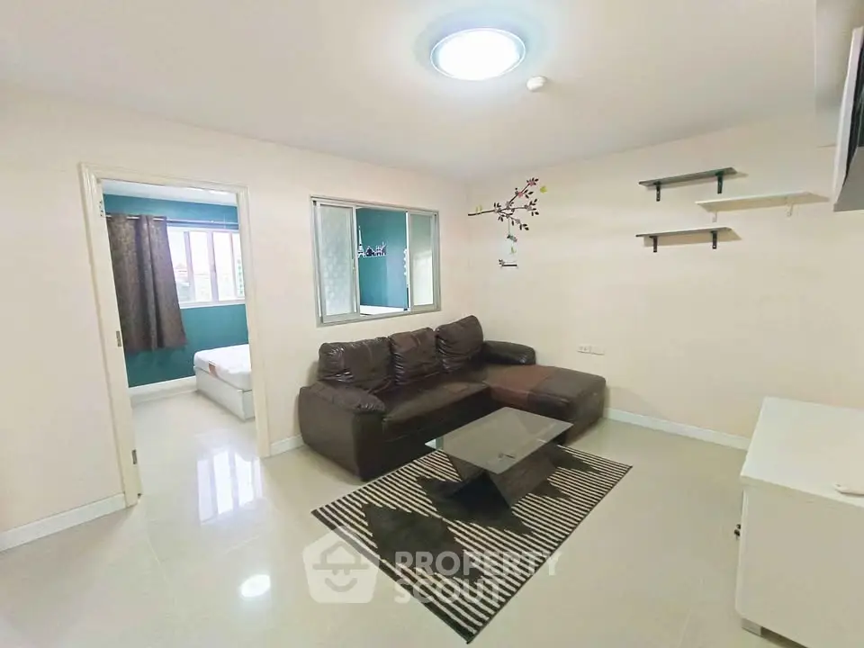 Cozy living room with modern decor and adjacent bedroom in a stylish apartment.