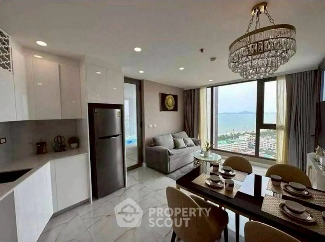 Luxurious open-plan living room with ocean view and elegant chandelier.
