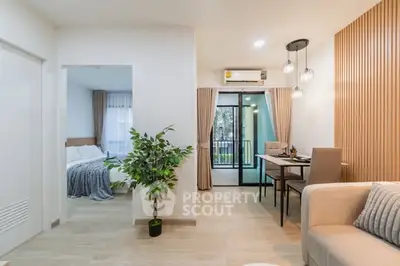 Modern open-plan living room with dining area and balcony access in a stylish apartment.