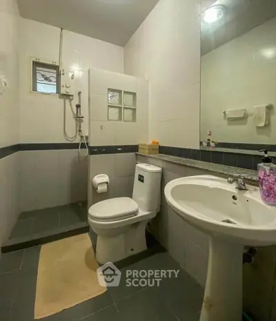 Modern bathroom with sleek fixtures and large mirror in a cozy apartment.
