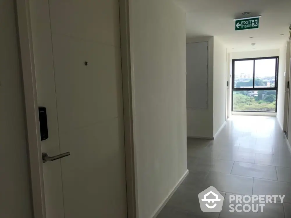 Modern apartment hallway with natural light and exit sign