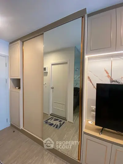 Modern bedroom with built-in wardrobe and sleek TV setup