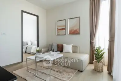 Modern living room with stylish decor and natural light, featuring a cozy seating area and elegant artwork.