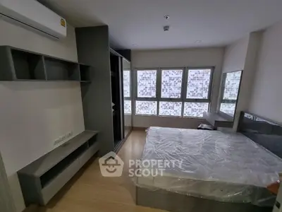 Modern bedroom with large windows and sleek furniture in a stylish apartment.