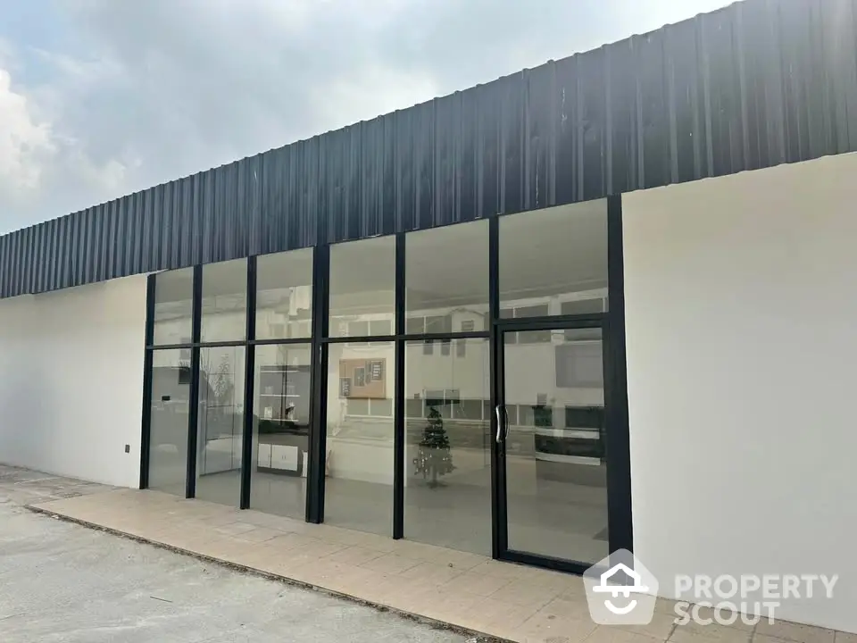 Modern commercial building exterior with large glass windows and sleek design.