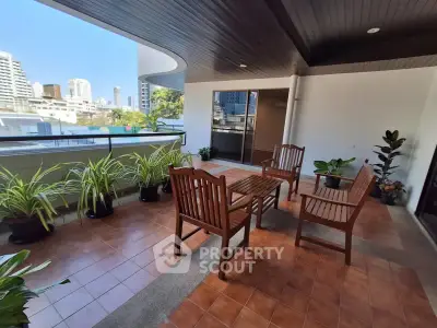 Spacious balcony with city view and stylish wooden furniture