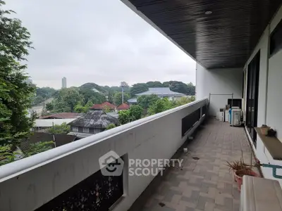 Spacious balcony with scenic view of lush greenery and cityscape