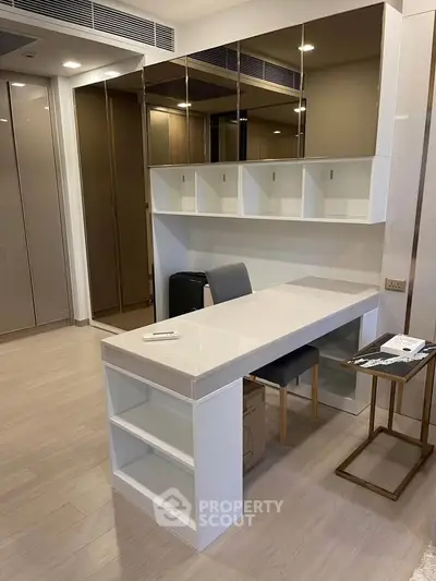 Modern study area with sleek desk and mirrored cabinets in a stylish apartment.