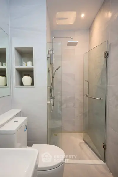Modern bathroom with glass shower and sleek fixtures in a contemporary home.