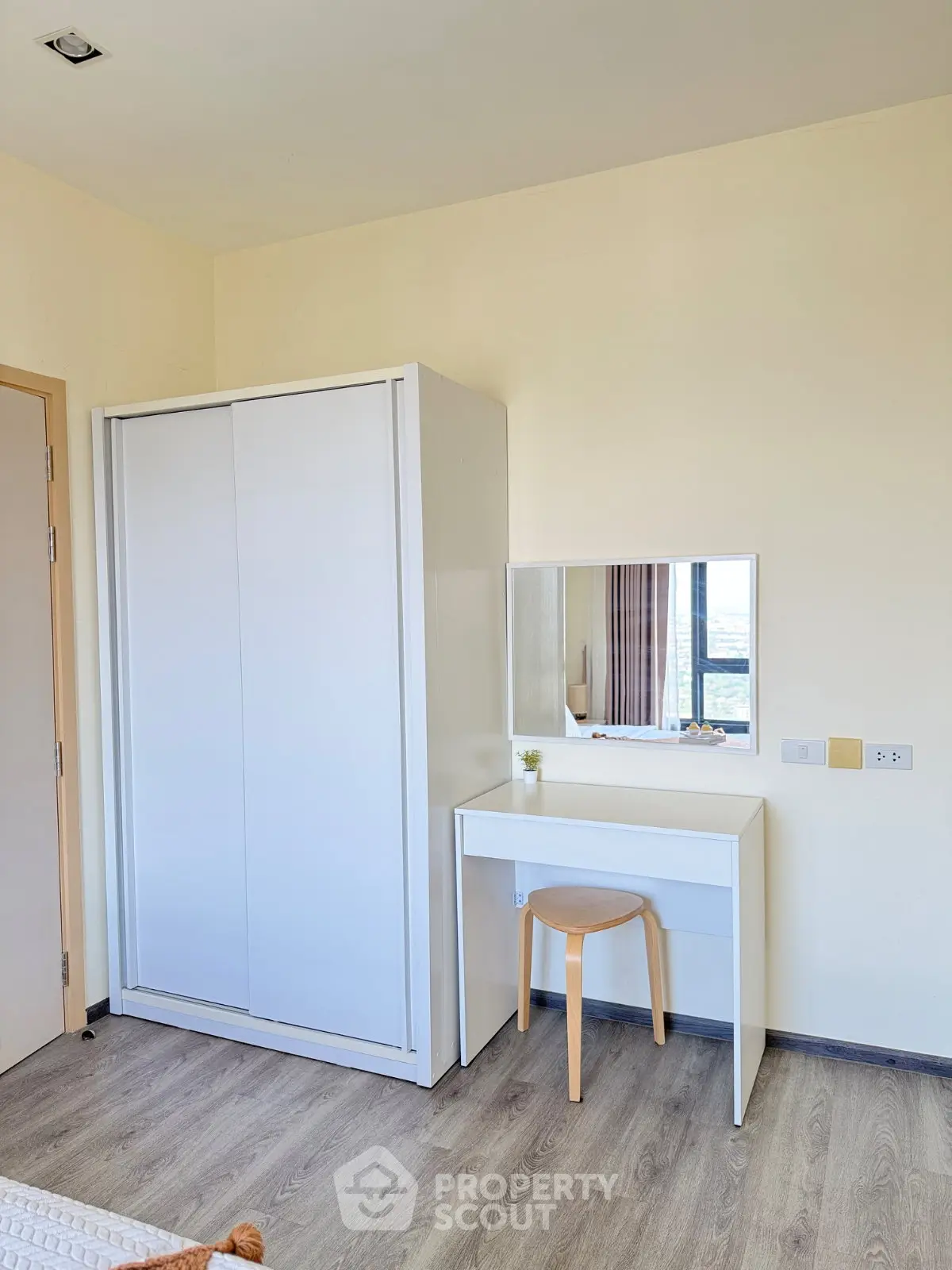 Modern bedroom with sleek white wardrobe and minimalist vanity set
